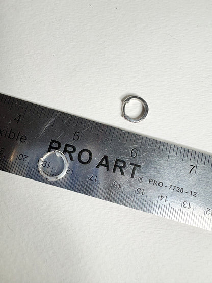 Sterling silver small huggie hoop earrings with rhodolite garnets, shown with a ruler.