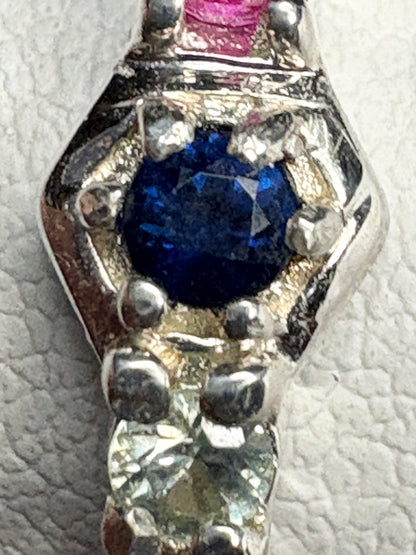 Sterling silver band ring with multi-colored sapphires and ruby in honeycomb pattern.
