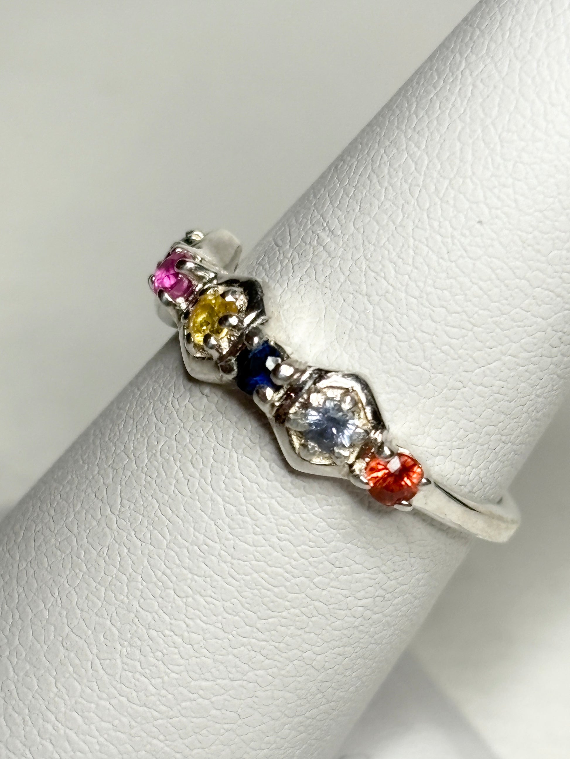Sterling silver band ring with multi-colored sapphires and ruby in honeycomb shapes.