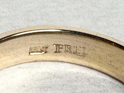 18k gold ring with channel-set diamonds and emeralds and milgrain detail.