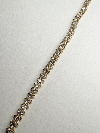 A 14k gold tennis bracelet with 57 round diamonds.