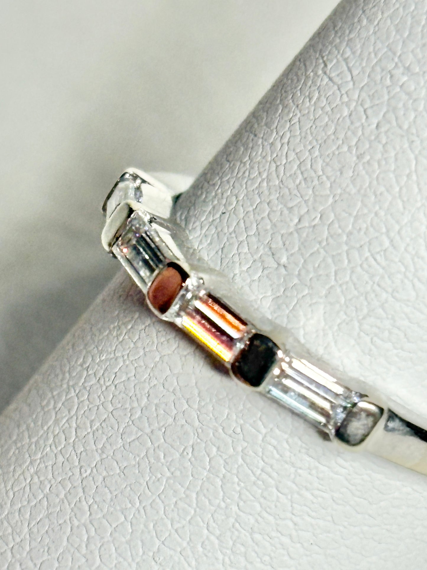 A white gold band ring with baguette-cut moissanite stones.