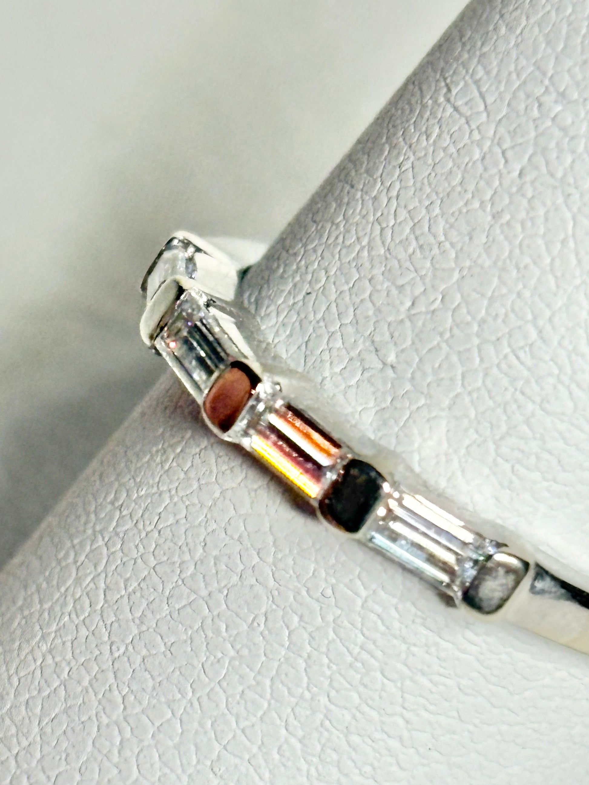 A white gold band ring with baguette-cut moissanite stones.