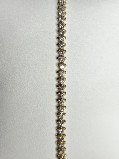 A 14k gold tennis bracelet with 57 round diamonds.