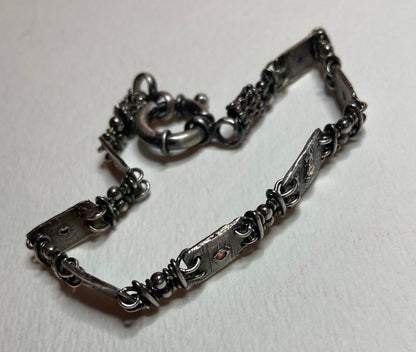 Hand forged sterling silver bracelet with multi-colored sapphire stations.