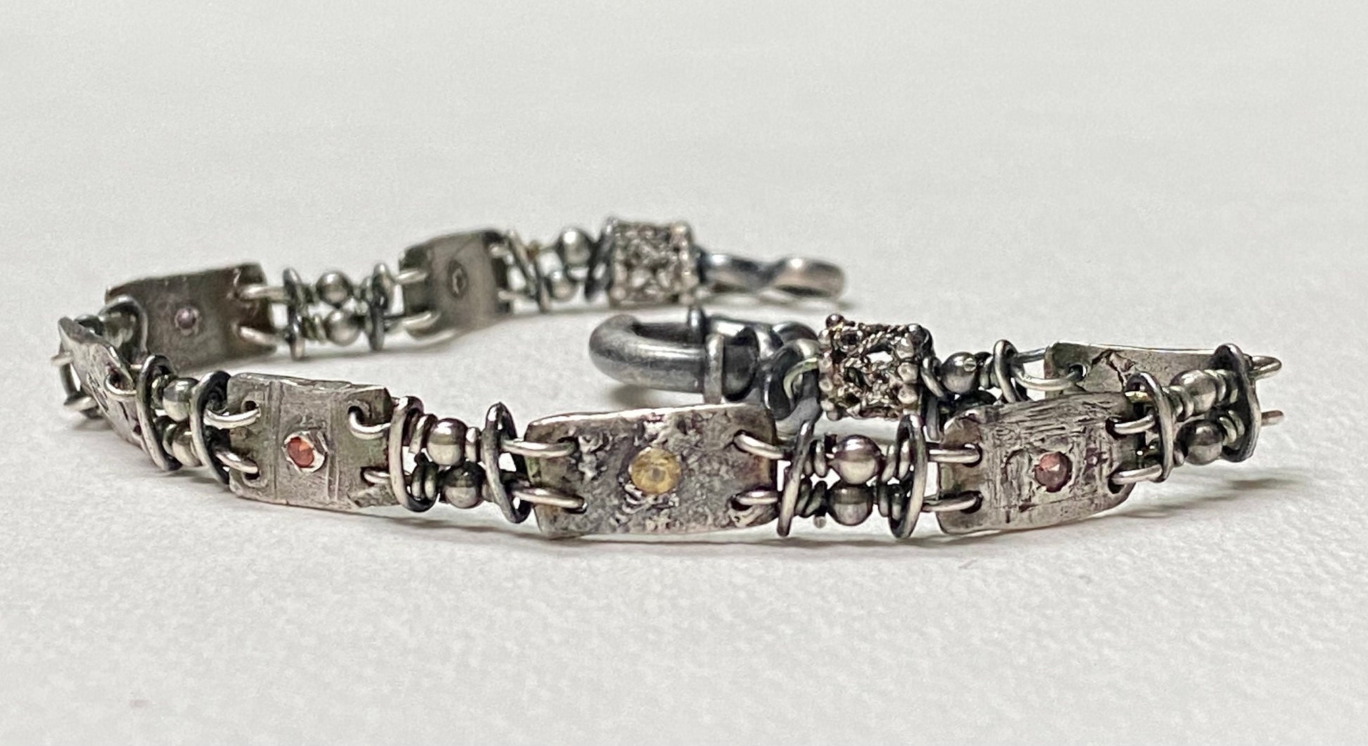 Multi-color sapphire fine PMC silver and sterling hand-forged station bracelet.