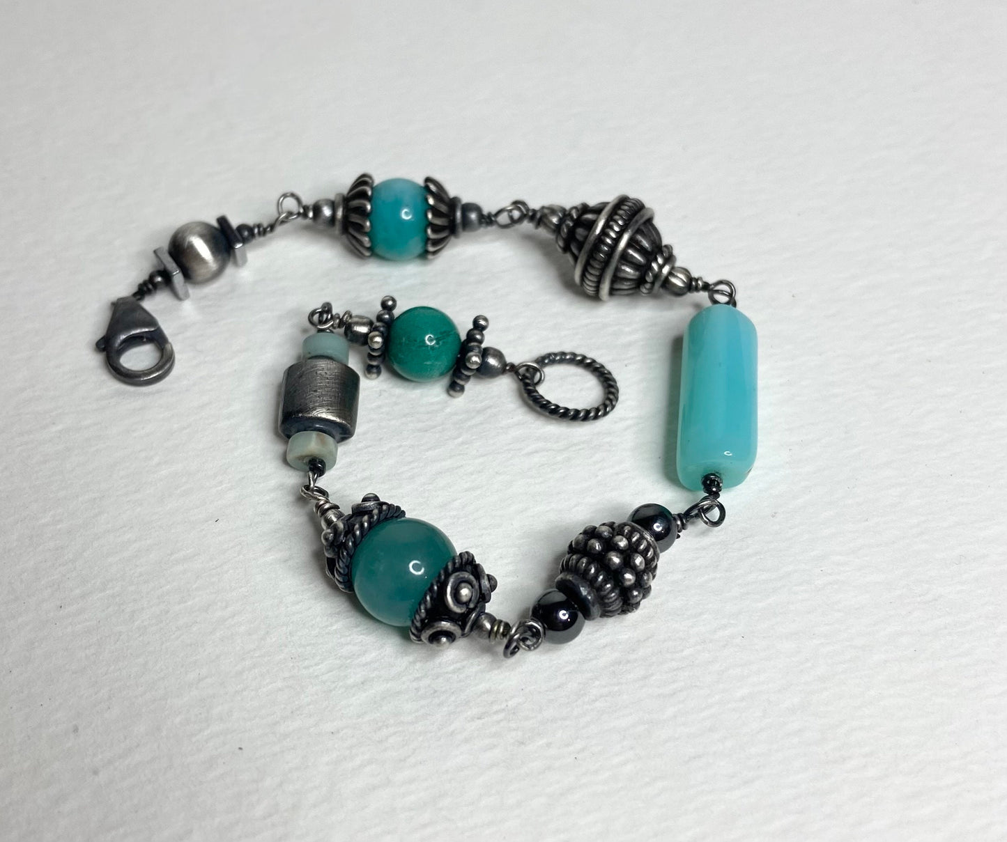 Eclectic sterling silver bracelet with blue beads and ornate silver accents.