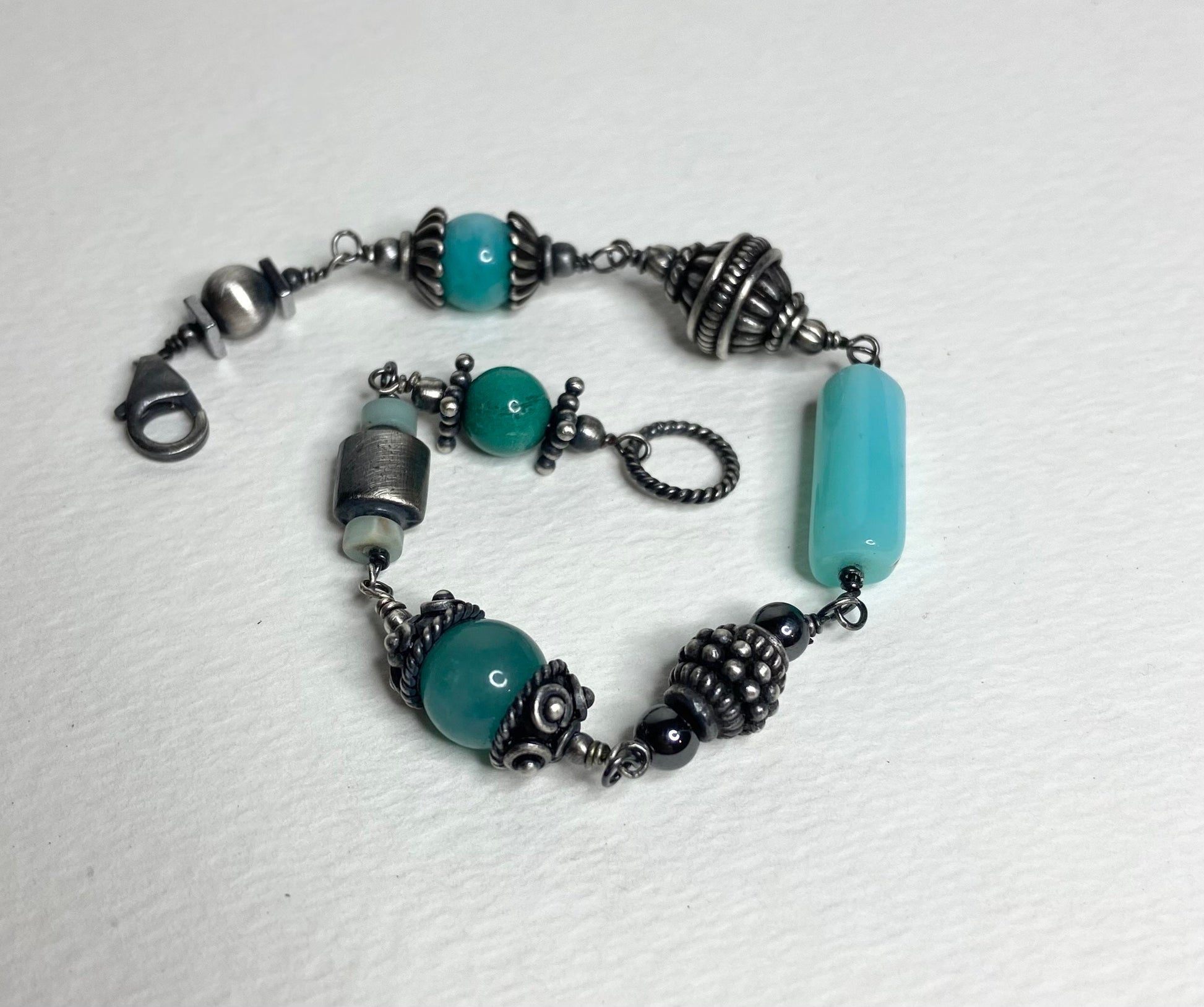 Eclectic sterling silver bracelet with blue beads and ornate silver accents.