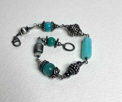 Eclectic sterling silver bracelet with blue beads and ornate silver accents.