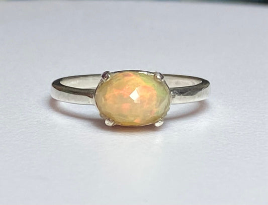 Sterling silver band ring with an oval faceted Ethiopian Wello opal.
