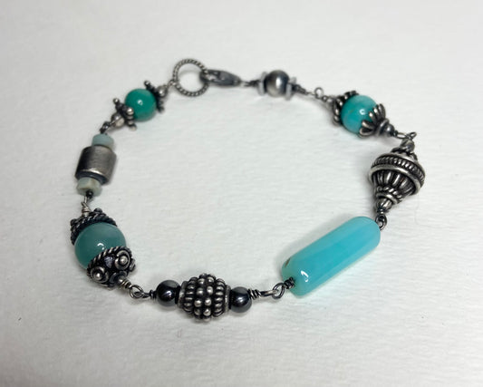Eclectic sterling silver bracelet with blue beads and ornate silver accents.