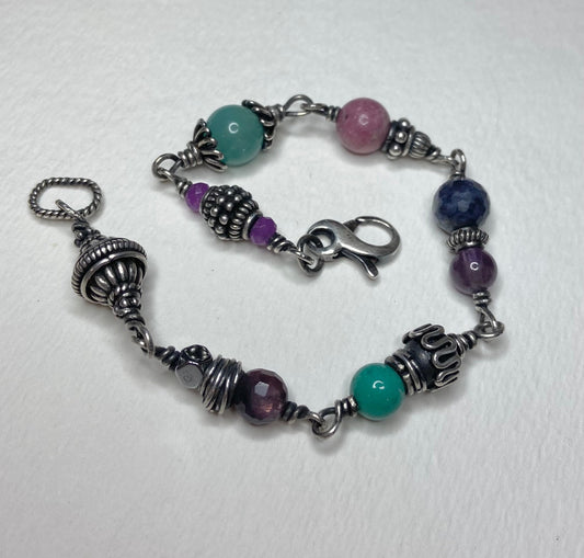 Sterling silver beaded bracelet with multi-colored gemstones and ornate silver accents.