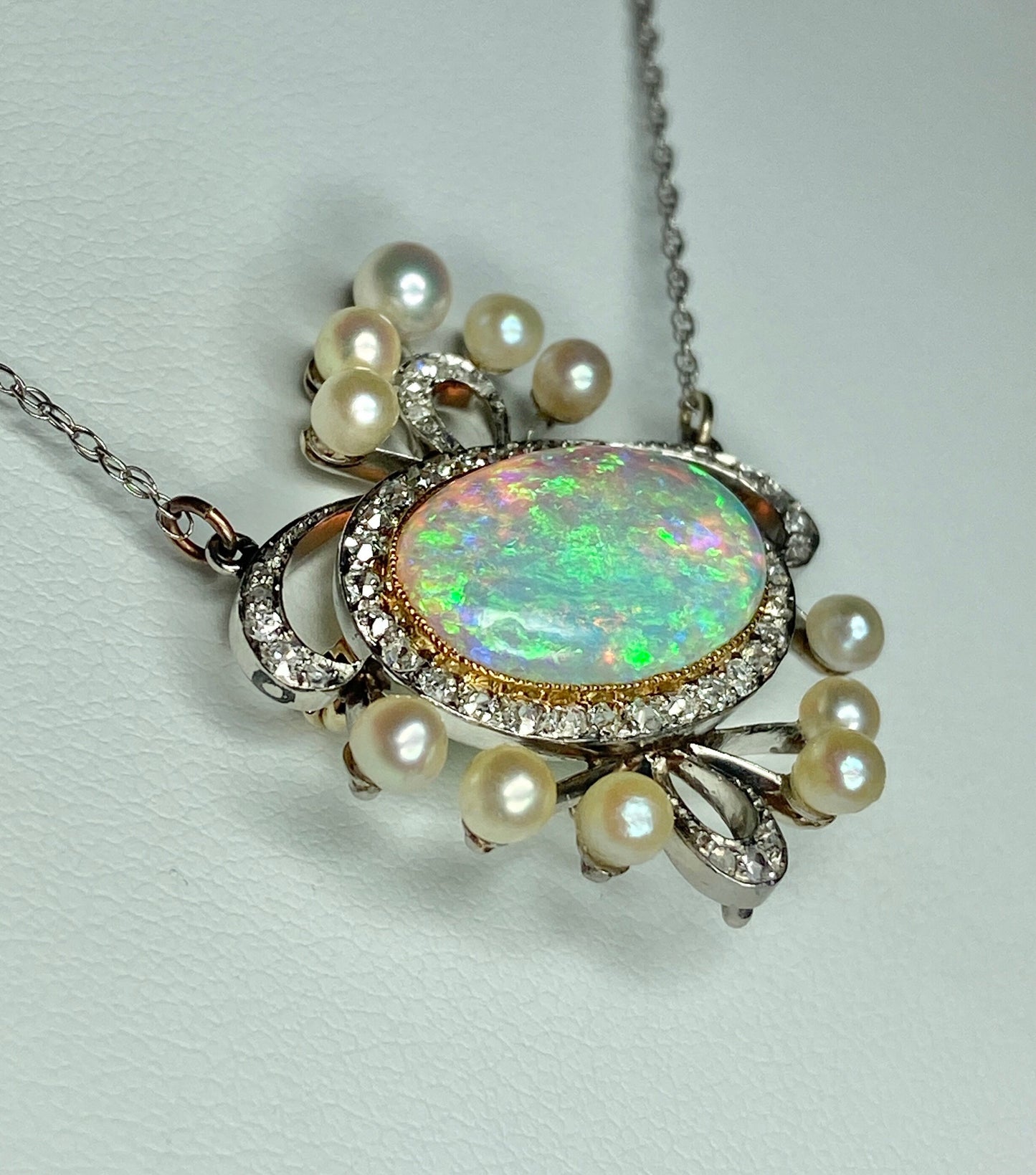Platinum, 18k, and 14k gold pendant necklace with opal, pearls, and diamonds.