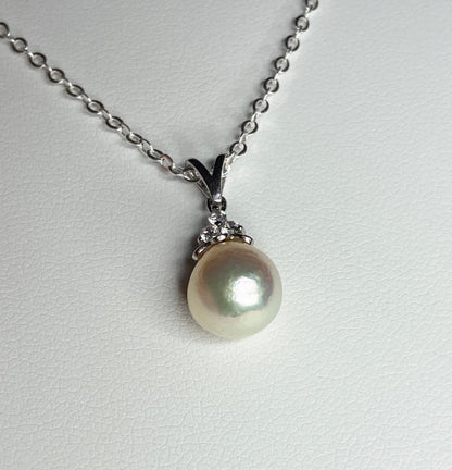 Sterling silver pendant necklace with an 8.5x8mm out-of-round Akoya pearl and three crystals.