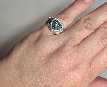 Sterling silver ring with a pave blue diamond heart and quilted band.