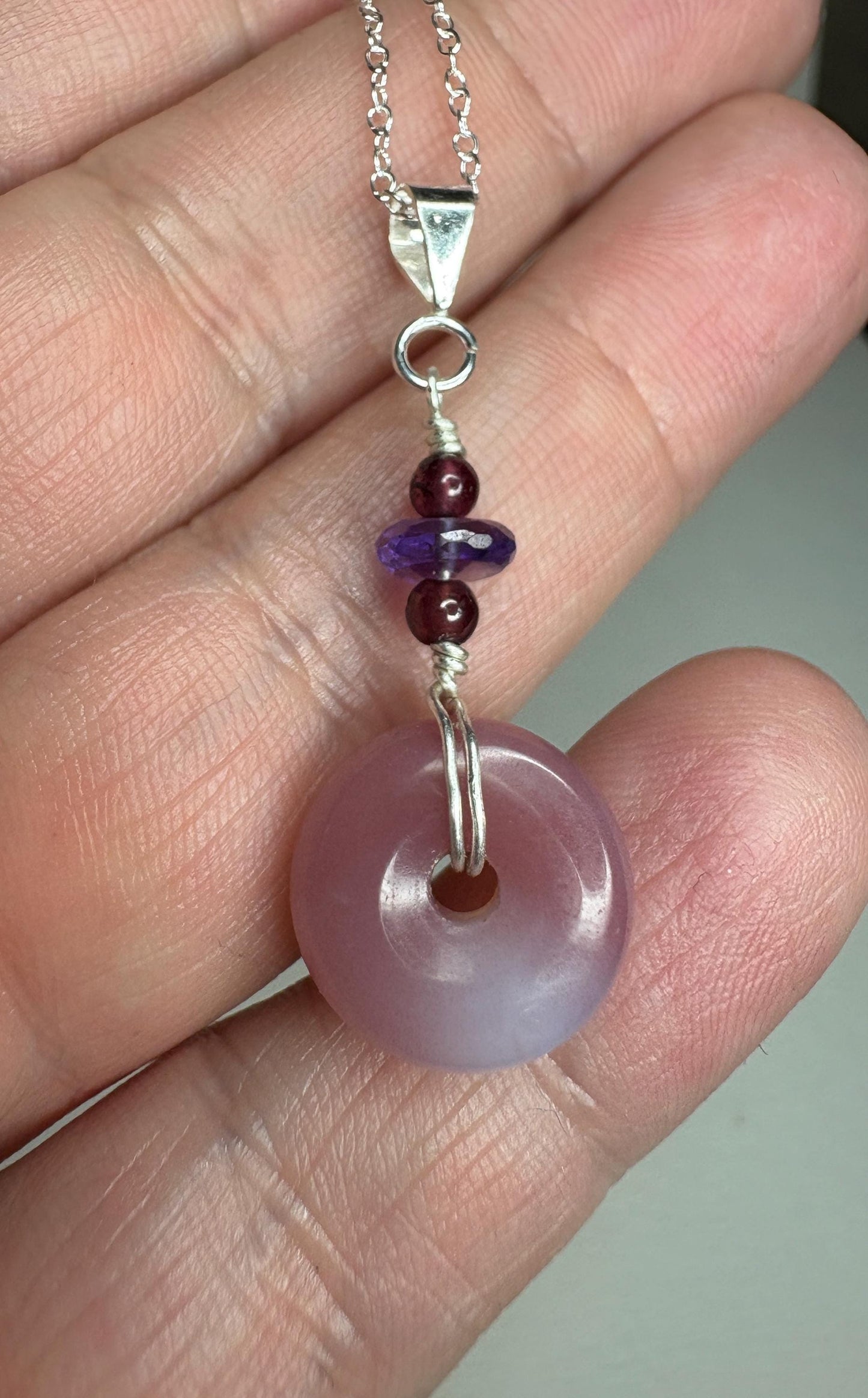 Sterling silver pendant necklace with untreated mauve-pink agate donut, amethyst, and garnet beads.