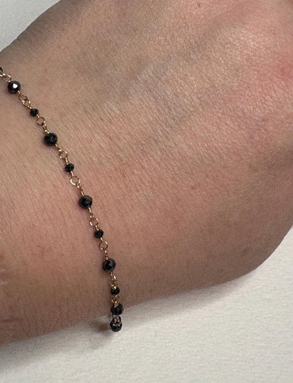 A 7-inch solid 14k gold bracelet with natural black diamond beads.