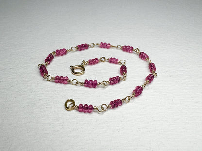 A delicate 14k gold bracelet with small, faceted hot pink spinel beads.