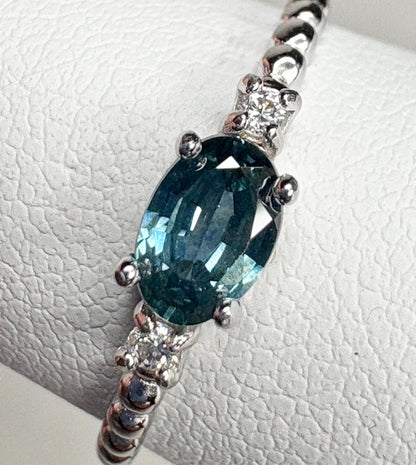 Sterling silver ring with oval Montana sapphire and two diamonds on a beaded band.