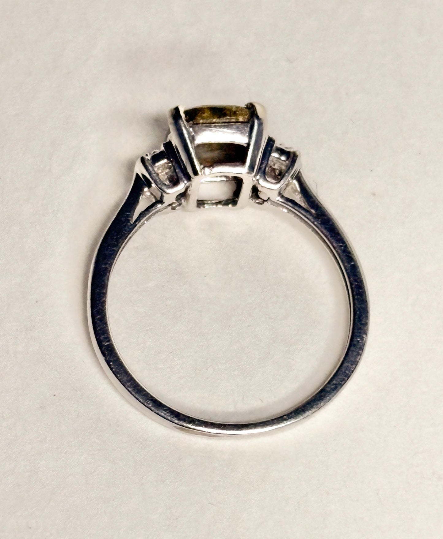 A 10k white gold ring with a cushion-cut gold in quartz center stone and small diamonds.