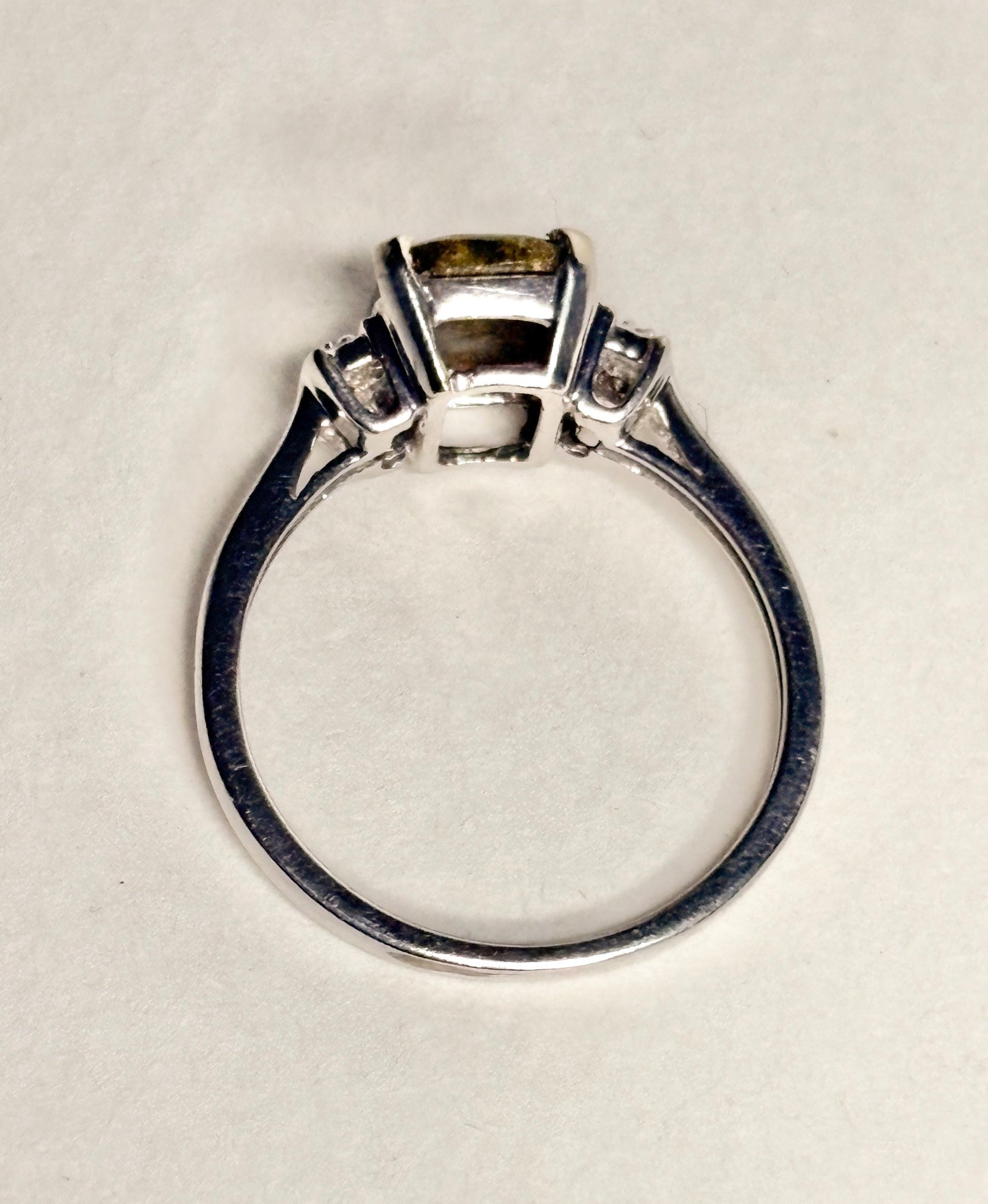 A 10k white gold ring with a cushion-cut gold in quartz center stone and small diamonds.