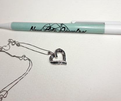 Sterling silver necklace with a heart pendant featuring blue and white diamonds.