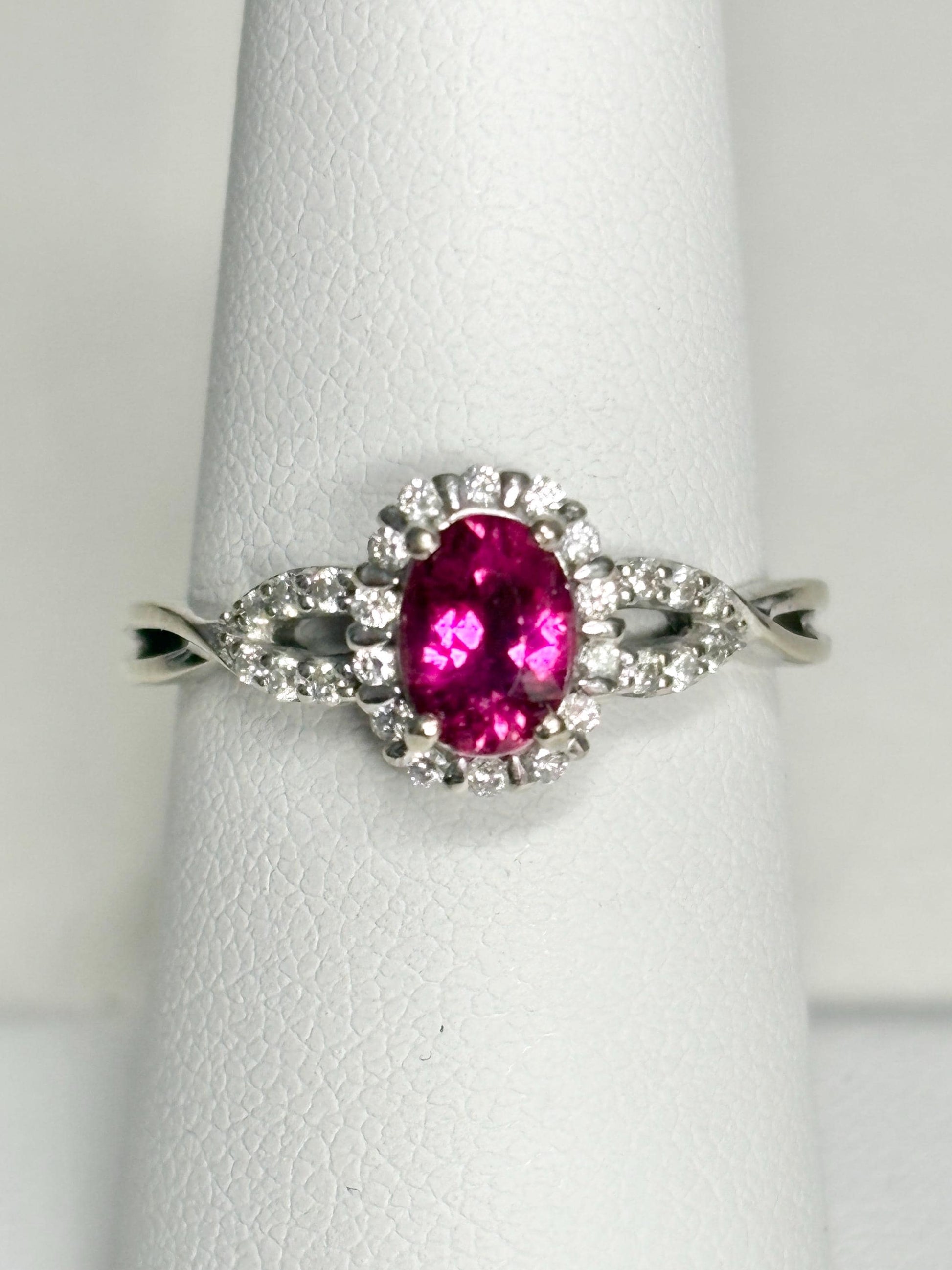 Oval rubellite tourmaline and diamond halo ring in 10k white gold.