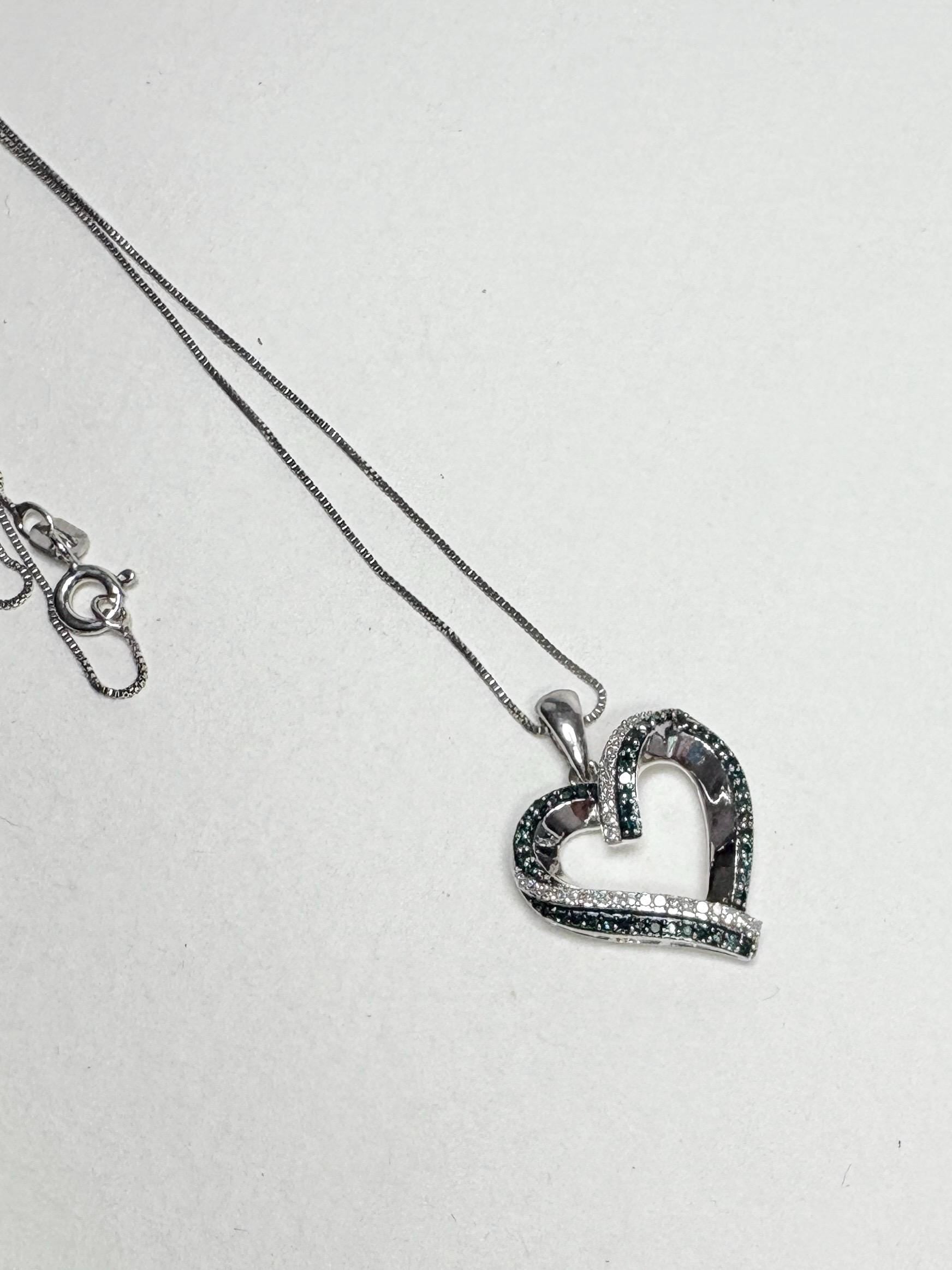 Sterling silver necklace with a heart pendant featuring blue and white diamonds.