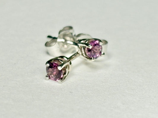 Pair of 14k white gold stud earrings with round rhodolite garnets.