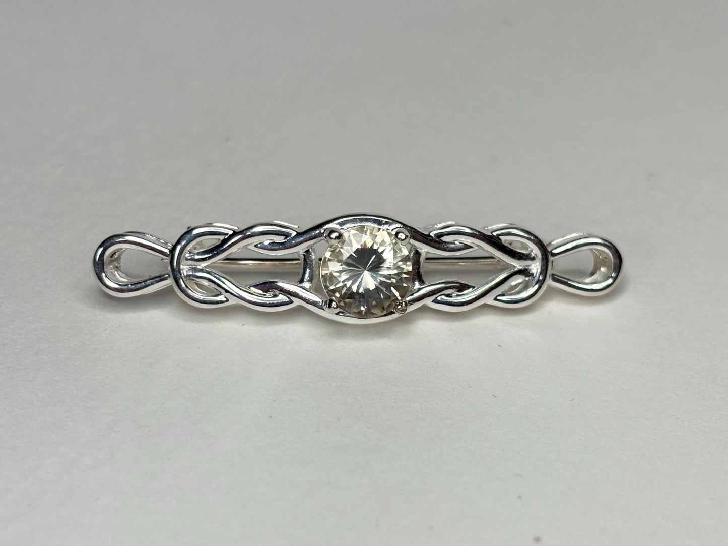Sterling silver brooch with a yellow Oregon sunstone and Celtic knot design.