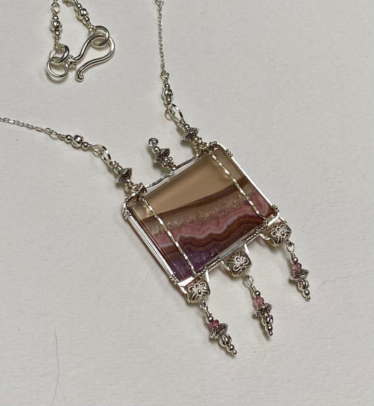 Sterling silver necklace with a rectangular agate and amethyst pendant and pink spinel accents.