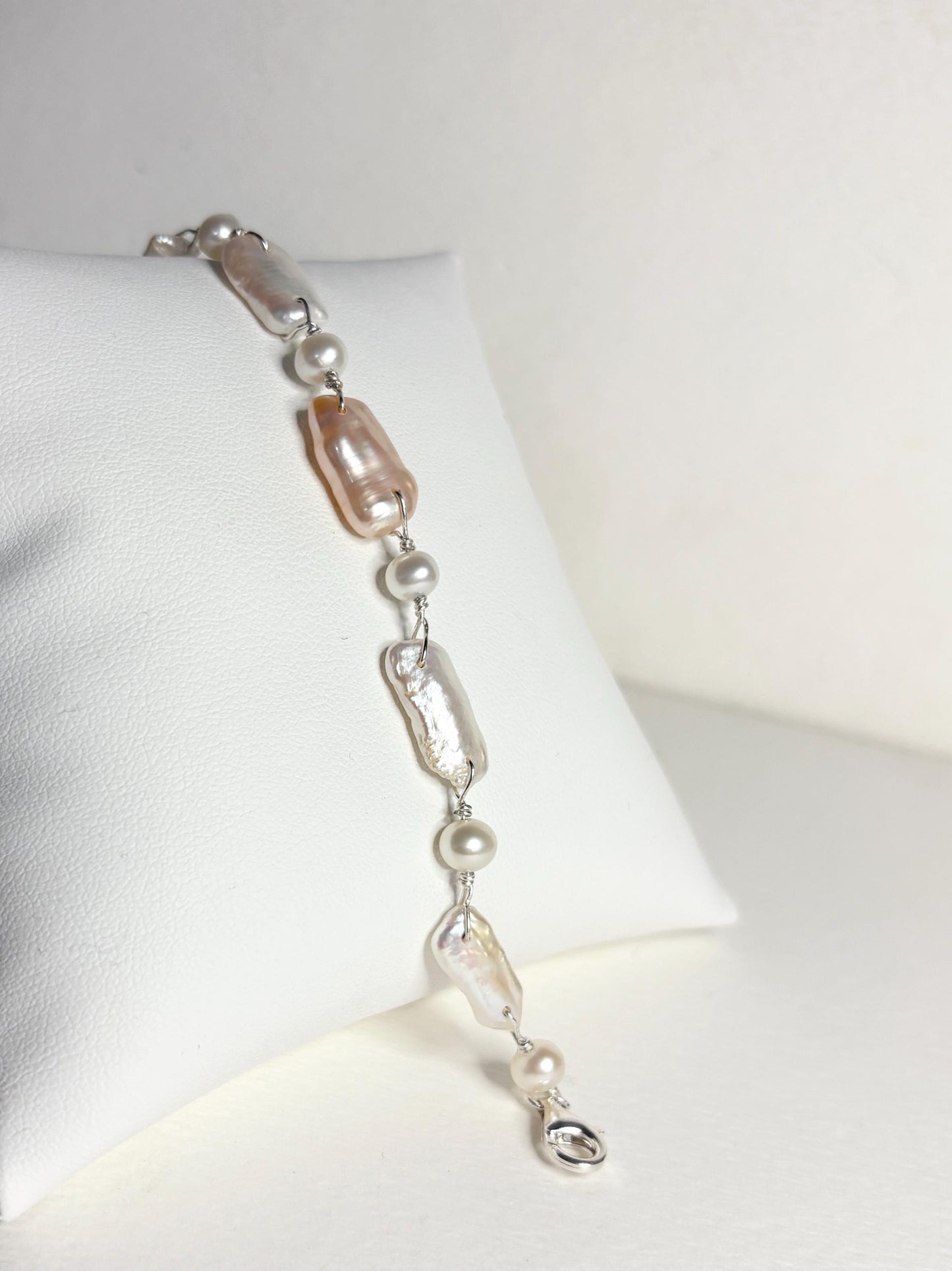 Sterling silver bracelet with irregular white and peach freshwater pearls.