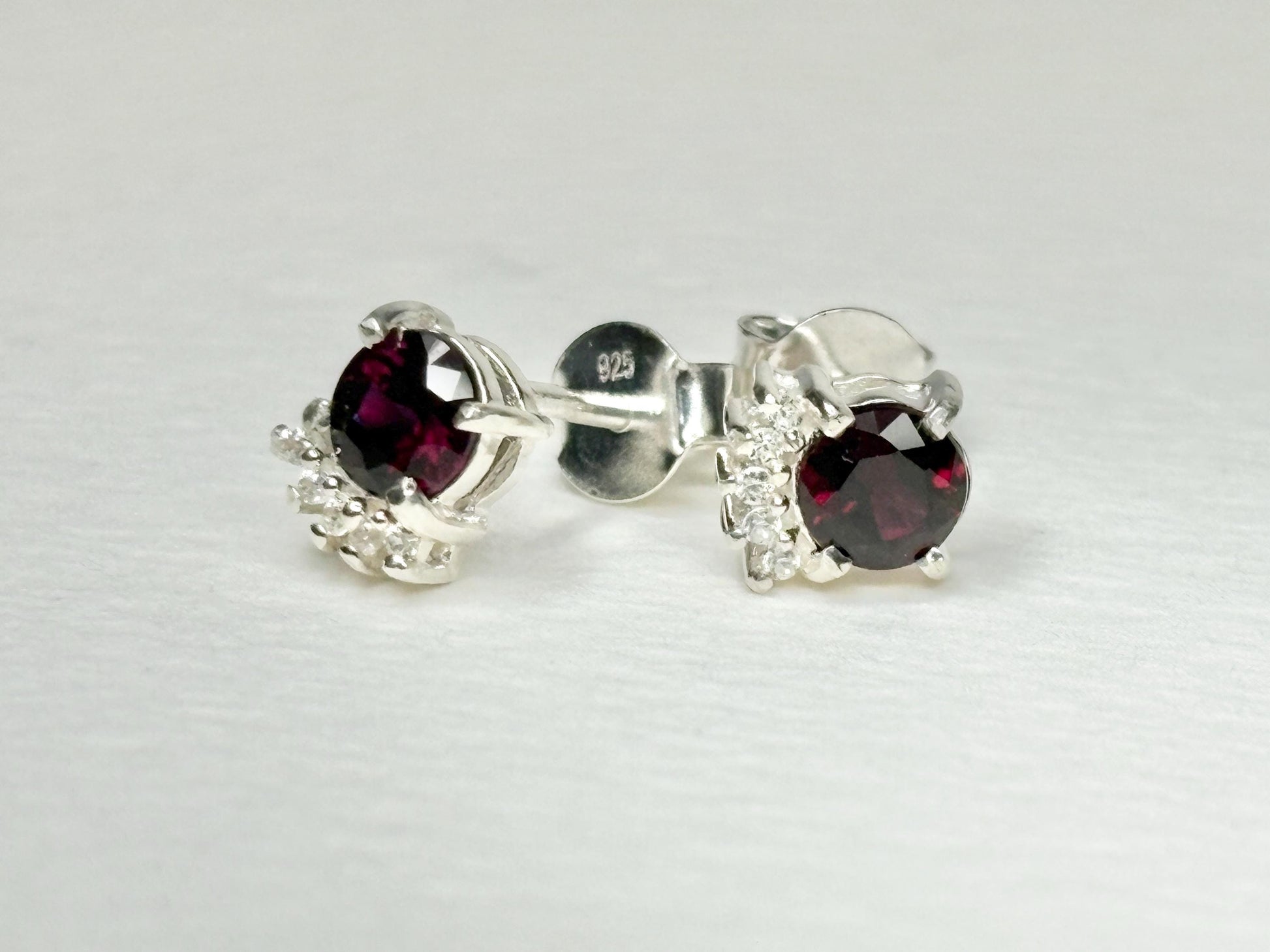 Sterling silver stud earrings with garnets and zircons.
