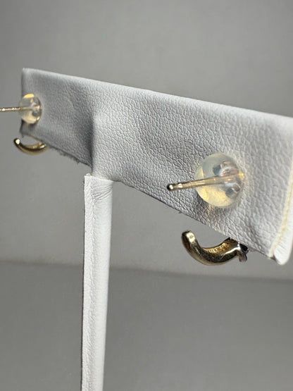 Tiny 14k gold partial hoop stud earrings with diamonds.