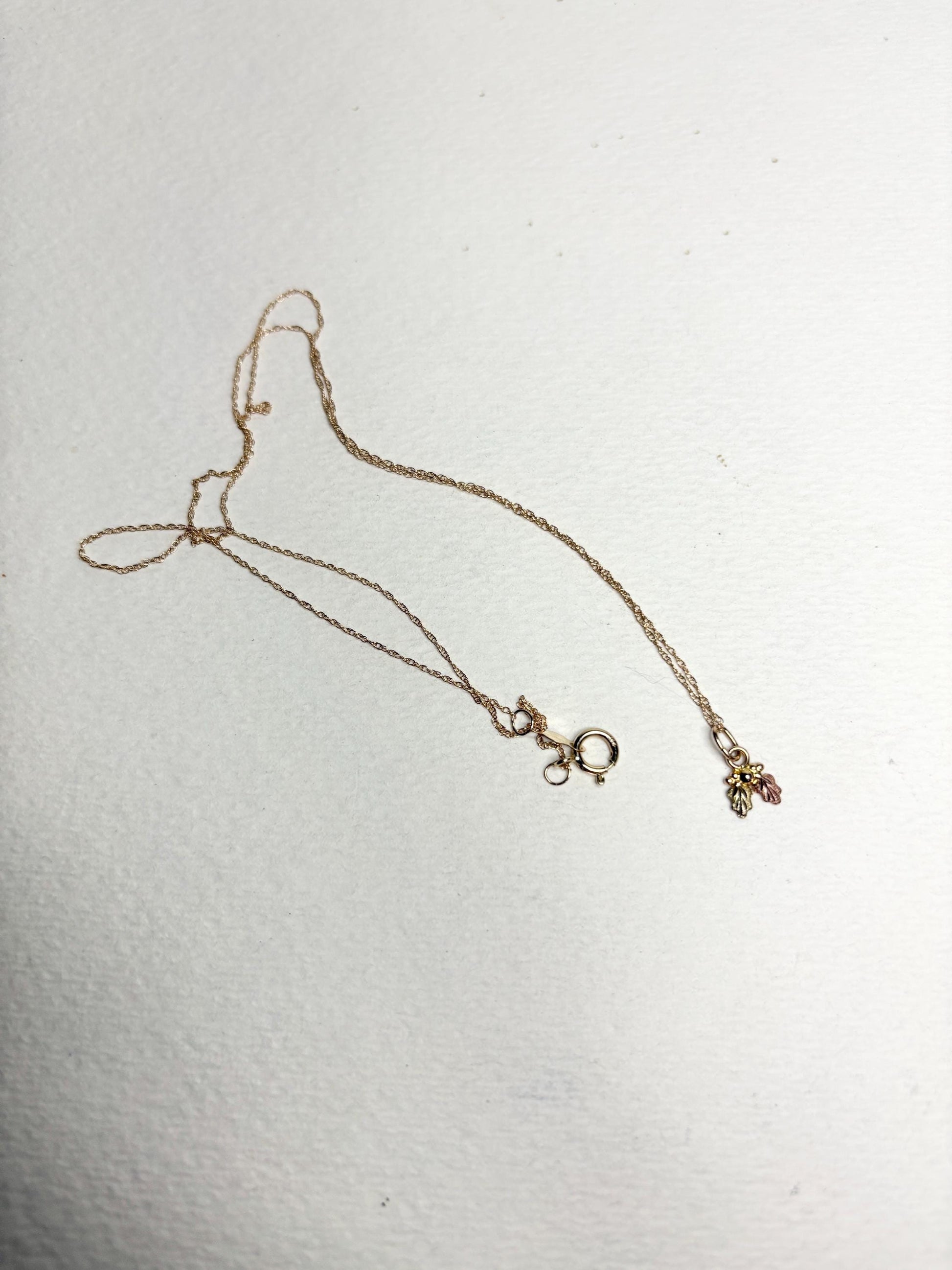 Dainty Black Hills Gold pendant necklace with three leaves on an 18-inch 10k gold chain.
